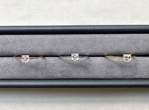 Detailed view of three Asscher cut moissanite rings in rose gold, silver, and gold finish