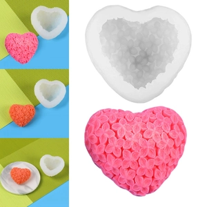 Detail of 3D heart silicone mold showing floral relief textures and finished candles