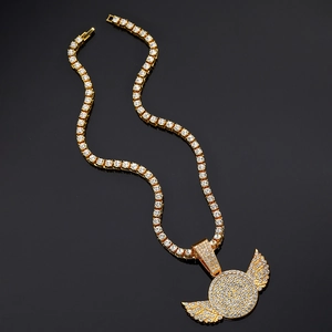 Close-up of gold iced out wings pendant and sparkling tennis chain necklace