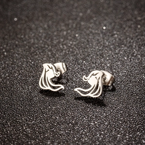 Detailed close-up of polished silver hollow wing earrings on a sparkling black background