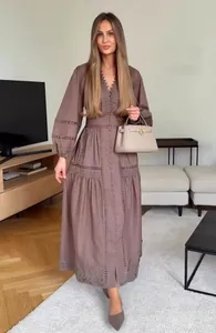 Detail von V-Ausschnitt, Spitzenstickerei und Knöpfen an einem Bohème-Langarmkleid