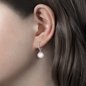 Close-up of elegant S925 silver pearl drop earrings worn on a model's ear
