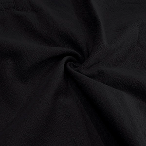 Close-up of black linen fabric texture and drape of the men's summer beach shirt