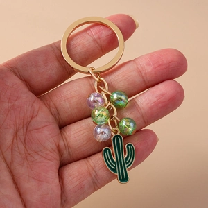 Pastoral beaded cactus keychain with purple glass beads and green enamel pendant on gold ring