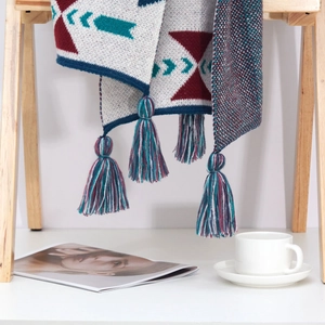 Detail of bohemian knit shawl with colorful geometric patterns and long fringe tassels