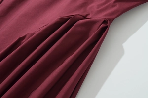 Close-up of the wine red woven fabric texture and pleated detail on the french dress