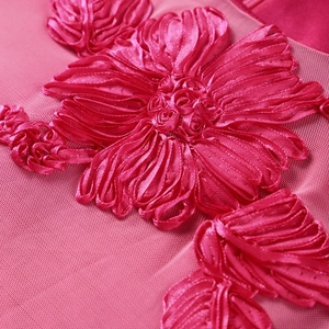 Macro detail of 3D rose pink satin ribbon flowers on mesh fabric for dress