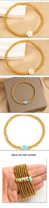 Detail of gold beaded stretch bracelets with moon, fish, and hand-shaped charms