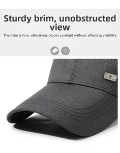 Detail of dark grey baseball cap showing twill fabric texture and metallic brand logo