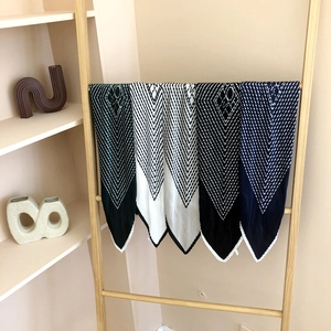 Pleated silk-like square scarf featuring geometric V-stripes in green, white, and black