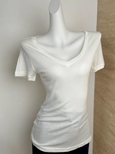 Detailed view of white V-neck wool t-shirt with soft texture on a mannequin