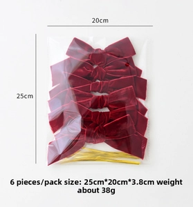 Detail of 6pcs red velvet Christmas bows with golden twist ties in packaging