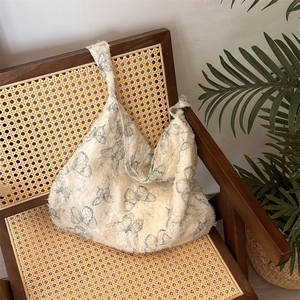 Close-up of lace butterfly tote bag with fringe texture on a vintage wooden chair