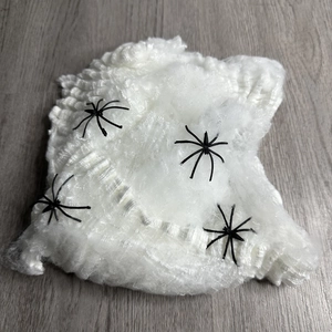 Luminous Halloween spider web decoration with black spiders on a wooden surface