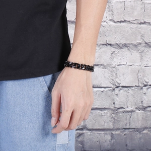 Close-up of black stainless steel Cuban link bracelet worn on wrist with lobster clasp