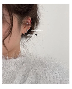 Detail shot of silver snowflake stud and black heart pendant earring set for women