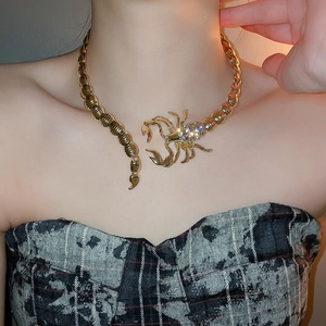 Detailed close-up of a golden scorpion choker necklace with rhinestones on model