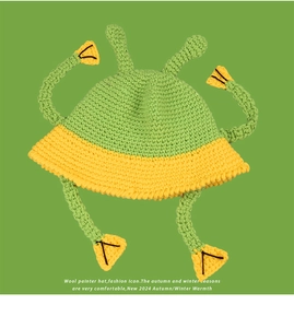 Detail of green and yellow handmade wool knit bucket hat with cartoon alien antennae