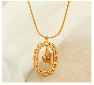 Détail d'un pendentif ovale doré avec une tulipe 3D et des bords ondulés