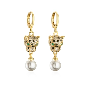 Detailed view of gold-plated leopard earrings with green zircon eyes and hanging white pearl