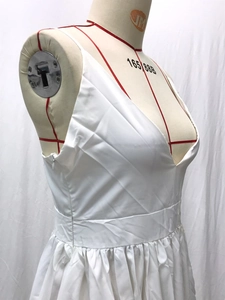 Detail view of the white deep V-neck dress side zipper and high-waist pleated texture