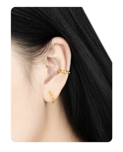 Macro shot of gold S925 silver hoop earring with vertical texture and studded ear cuff