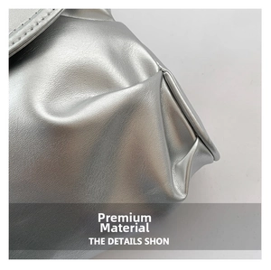 Close-up of silver pleated faux leather texture with fine stitching on a shoulder bag
