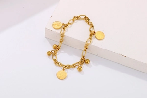 Dettaglio del bracciale vintage con monete d'oro e ritratti di Elisabetta II su base geometrica