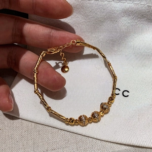 18K gold plated bamboo link bracelet with zircon inlay shown in hand display