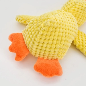 Dettaglio del tessuto in peluche giallo a bolle e zampa arancione su un gioco per cani