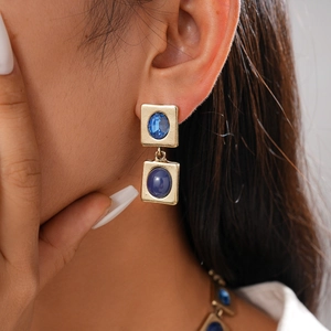 Detail von Vintage-Goldohrringen mit blauen ovalen Edelsteinen und geometrischem Design