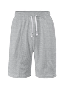 Macro detail of grey waffle knit fabric texture and white drawstring on men's shorts