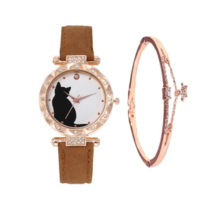Detail showing a rose gold cat motif watch with brown suede strap and matching star bracelet