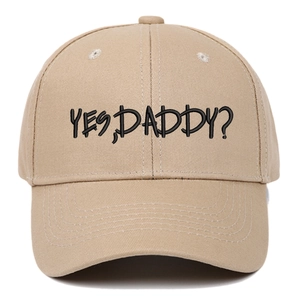 Close-up of black 'YES, DADDY?' embroidery on a khaki cotton baseball cap with fine stitching