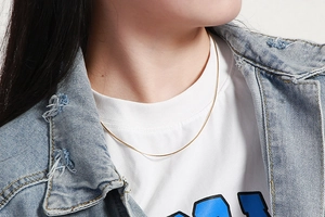 Close-up of a minimalist gold snake chain necklace worn on a model for daily styling