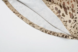 Detailed macro view of the leopard print fabric texture and reinforced hem stitching
