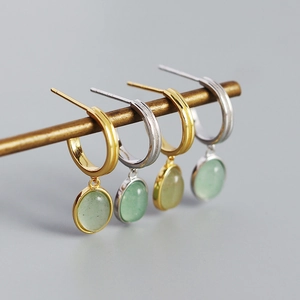 Detail of C-shaped S925 silver hoop earrings with green aventurine stone pendants