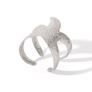 Macro detail of silver hammered starfish cuff bracelet with textured metallic finish