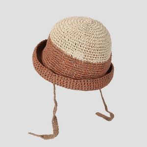 Detalle de sombrero de paja tejido a mano con cintas en contraste y malla bicolor fresca