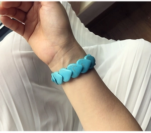 Detail shot of heart-shaped turquoise stone beads with natural texture on elastic bracelet