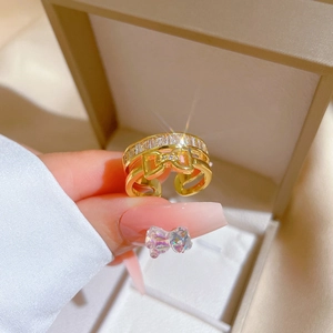 Close-up of gold plated bow ring with clear crystals on a velvet jewelry box