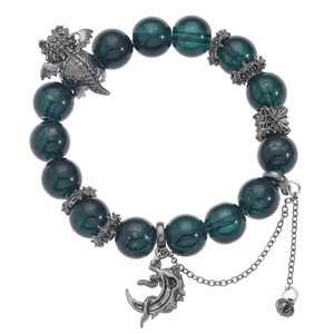 Dark green beaded bracelet with dragon charm and crescent moon pendant on white background