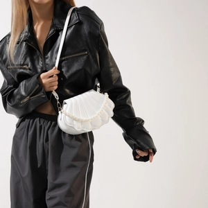 Detail of white shell-shaped PU leather crossbody bag with decorative pearl chain strap