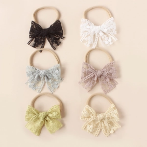 Set of 6 lace bow baby headbands in soft colors including white and pink on nylon bands