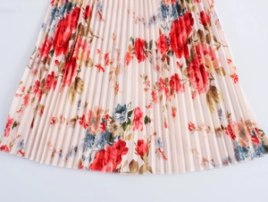 Detail of French romantic floral pleated dress with red and blue flowers on beige fabric
