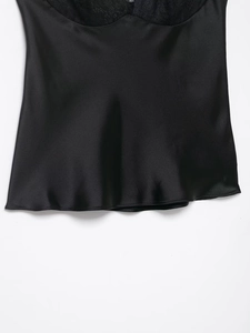 Détail de satin noir soyeux et bordure en dentelle délicate sur le haut féminin