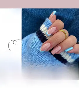 Detail view of blue French tip press-on nails with heart patterns and glue kit