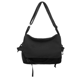 Minimalist black canvas messenger bag for men with adjustable strap on white background