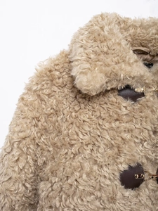 Detail of camel faux fur jacket showing plush texture and brown leather buckle