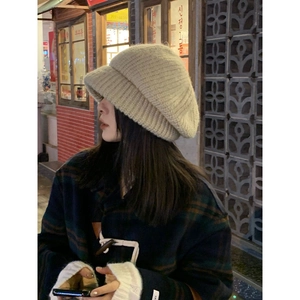 Oversized beige knit beret for women, loose fit style shown on model in evening street setting